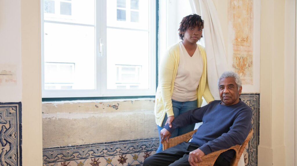 Profissional de apoio domiciliário com utente idoso. Cuidados de saúde ao domicílio.